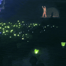 a man stands on a stage with his arms up in the air