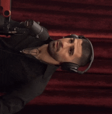 a man wearing headphones and a shirt with a tattoo of the letter t on it