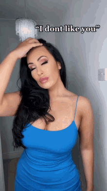 a woman in a blue dress holds her hand to her head and says " i don 't like you "