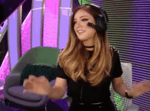 a woman wearing a headset is sitting in a chair .