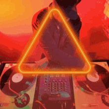 a neon triangle is behind a dj playing records