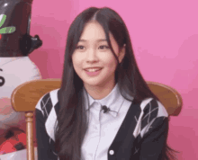 a girl with long hair is sitting in a chair with a microphone on her neck