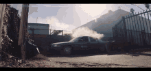 a taxi cab with smoke coming out of it is parked in front of a fence
