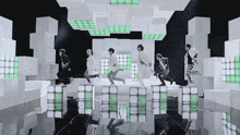 a group of young men are dancing in a room with white cubes