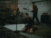 a woman is singing into a microphone while a man plays drums