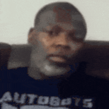 a man with a beard is wearing a blue shirt that says autobots