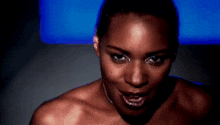 a close up of a woman 's face with a blue background behind her