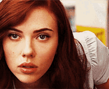 a close up of a woman 's face with red hair