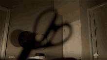 a shadow of a person is cast on a wall with the nbc logo in the background