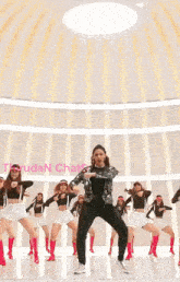 a woman in a silver jacket is dancing with a group of other women