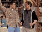 two men in plaid shirts are dancing together