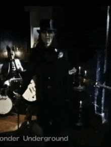 a man in a top hat is standing in front of a drum set with the words onder underground written on the bottom
