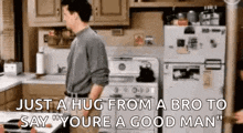 a man is standing in a kitchen with a fridge and stove .