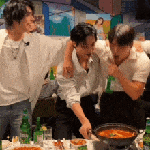 a group of men are standing around a table with bottles of terra beer