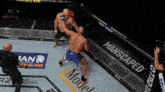 a man is fighting another man in a boxing ring with a manscaped banner behind him
