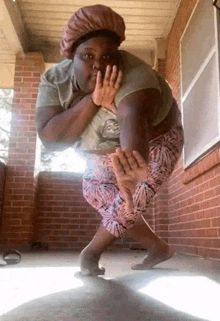 a woman is standing on a porch with her hands on her face .