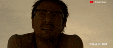 a close up of a man wearing glasses with a youtube logo above him