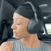 a woman wearing a headband and headphones is sitting in the back of a car