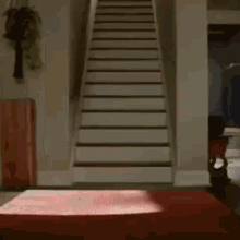 a person is walking up a set of white stairs in a living room .