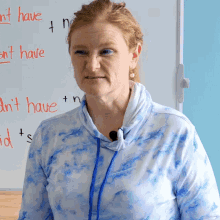 a woman stands in front of a white board that says ' i n't have ' on it