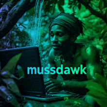 a man is using a laptop with mussdawk written in blue