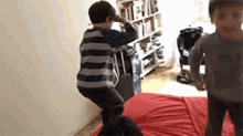 a group of children are playing on a bed in a room .