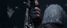 a person with gray hair is holding a sword in their hand