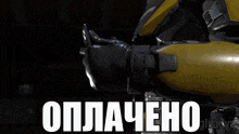 a man with a helmet and gloves is holding a watch and says " оплатено "