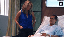 a woman stands next to a man in a hospital bed with a sign that says follow us