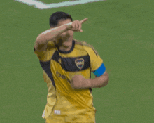 a soccer player wearing a yellow and black jersey with the letter b on the front
