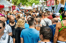 a crowd of people are gathered at a festival and one man has a tattoo on his back that says dragon