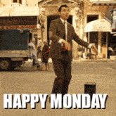 a man in a suit and tie is dancing on a street with the words happy monday behind him