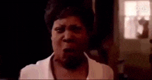 a woman is making a funny face in a dark room .