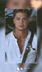 a man wearing a white shirt and a necklace with hearts around him