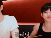 two men are sitting next to each other and one has a tattoo on his arm that says ' a '