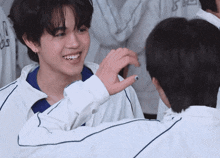 a boy wearing a white jacket with the letter s on it