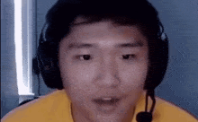 a man wearing headphones and a microphone is looking at the camera and making a funny face .