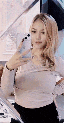a woman is taking a picture of herself with her iphone