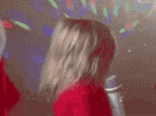 a little girl is singing into a microphone in a room .