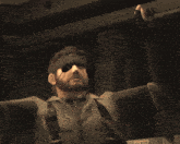 a man with a beard wearing a visor and eye patch looks down