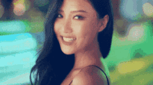 a close up of a woman 's face with a blurry background and a smile on her face .