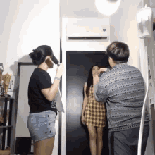 a man taking a picture of a woman in a plaid dress