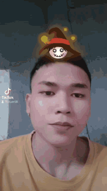 a man with a witch hat on his head has a tik tok sticker on his face