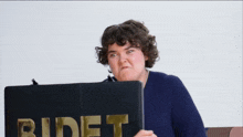 a woman is making a funny face while holding a tablet that says bidet