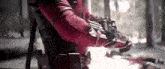 a man in a red suit is holding a gun in his hands .