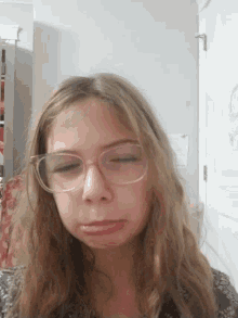 a girl wearing glasses looks down at the camera