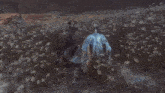 a man in a kimono is kneeling down in the grass