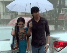 a man is holding an umbrella over a woman in the rain