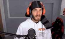 a man wearing headphones and a nasa hoodie