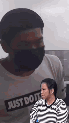 a man wearing a mask and a shirt that says just do it on it